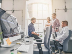 Mitarbeitende unterhalten sich bei der Arbeit. 