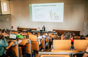Referentin spricht im Hörsaal über Vorteile der LTI-Integration von evasys