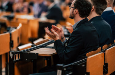 Teilnehmer applaudiert während einer Session der evasys Tagung 2023