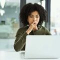 Frau macht in einer Firma einen Test am Laptop