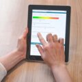 Person füllt auf einem Tablet eine digitale Umfrage mit Farbskala und Bewertungsskala aus