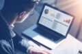 Laptop mit geöffneter Umfrageanalyse, Person arbeitet an der Auswertung von Feedbackdaten 