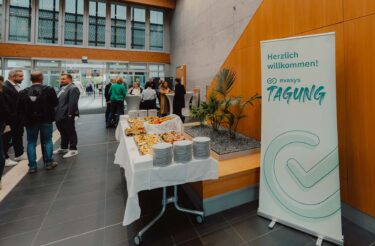Eingangsbereich der evasys-Tagung mit Buffet und Begrüßungsbanner