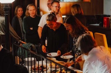 Teilnehmende bedienen sich am Buffet während der Abendveranstaltung der evasys-Tagung
