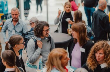 Menschen im Foyer der evasys-Tagung im Gespräch während der Pause