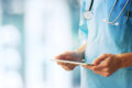 Medizinisches Fachpersonal mit Stethoskop und Tablet, Fokus auf digitale Feedbackprozesse im Gesundheitswesen 