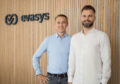 Silvio Ewert and Boy Hengstmann in front of the evasys logo