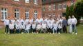 Gruppenfoto des evasys Teams – Kolleg*innen verschiedener Abteilungen stehen gemeinsam und lächeln in die Kamera.